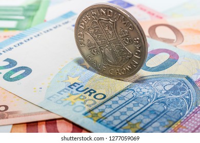 half crown coin on top of euros banknotes