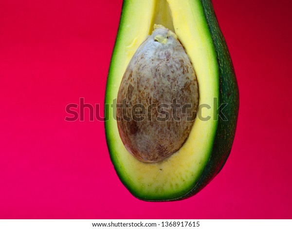 Half Cut Avocado Seed On Magenta Stock Photo Edit Now Half Cut Avocado Seed On Magenta Stock Photo Edit Now