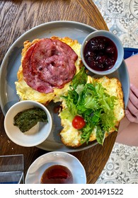 Half Cut Croissant Sandwich With Bacon, Scrambled Egg, Pesto Sauce And Marmalade Jam In Breakfast Plate.