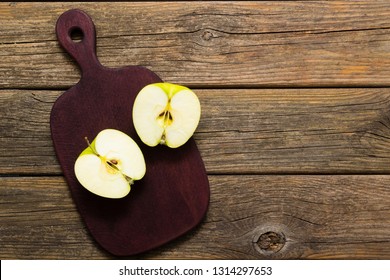 Half Cut Green Apple On Chopping Board, Old Wooden Table 