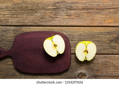 Half Cut Green Apple On Chopping Board, Old Wooden Table 