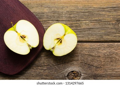 Half Cut Green Apple On Chopping Board, Old Wooden Table 