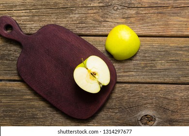 Half Cut Green Apple On Chopping Board, Old Wooden Table 