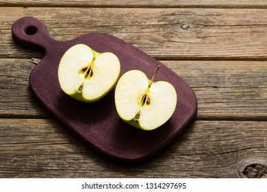 Half Cut Green Apple On Chopping Board, Old Wooden Table 