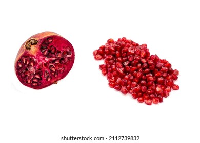 Half A Cut Red Pomegranate Fruit And A Pile Of Seeds Isolated On A White Background.