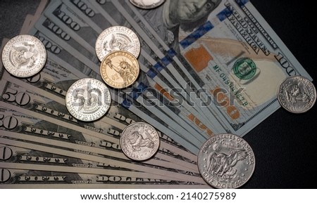 Half Dollar and Dollar coin on top of 100 US Dollar banknotes