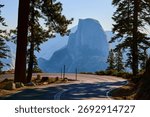 Half Dome Framed by Pine Trees and Winding Road at Glacier Point Yosemite California