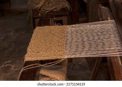 A half done hand crafted door mat made by jute on a hand made machine run by village women. Selective focus. - Shutterstock ID 2171134119