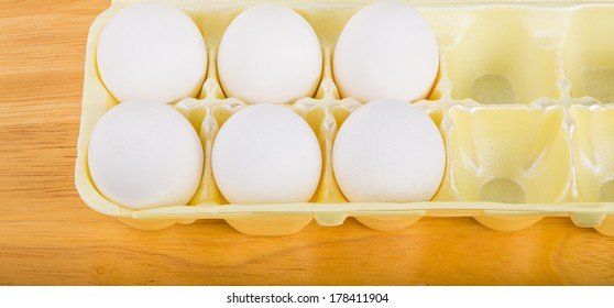 A Half Dozen Eggs In A Yellow Foam Egg Carton