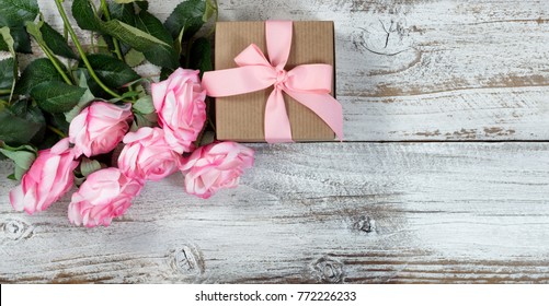 Half A Dozen Pink Roses And Gift Box On Rustic White Wood In Flat Lay View