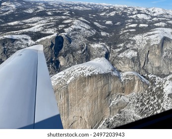 Half dune, from the view of a private plane, covered in snow. the plane wing in shot, as well as the blue sky - Powered by Shutterstock