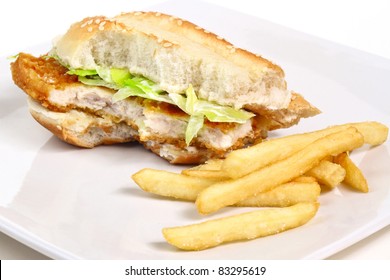 Half Eaten Chicken Burger With Chips On The Plate