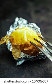 Half Eaten Delicious Baked Jacket Potato In Aluminium Foil For A Healthy Vegetarian Diet Or Accompaniment To A Picnic Or Barbecue