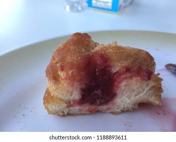 Half Eaten Jelly Donut On Plate