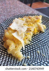 A Half Eaten Mac And Cheese On A White Dot Black Plate . American Food Or Cuisine .