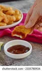 Half Eaten Piece Of Chicken Nugget With Bbq Sauce On