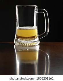 Half Empty Beer Mug On Wooden Plane And Black Background