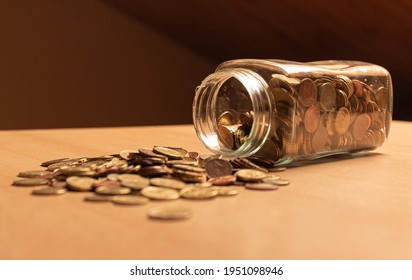 Half Empty Money Jar With Coins Over The Table. Save Money Concept Banner