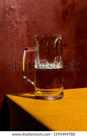 Half empty pint of blond beer, Ale or lager. Colorful background