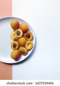 Half Empty Plate With Apricots On A White-orange Background.