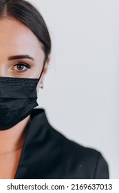 Half Face Of A Dentist In A Black Mask. Close-up Against Covid