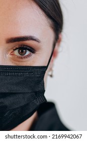 Half Face Of A Dentist In A Black Mask. Close-up Against Covid