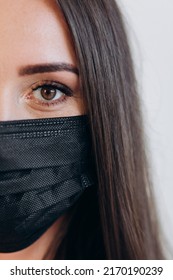 Half Face Of A Dentist In A Black Mask. Close-up Against Covid