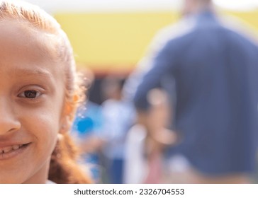 Half face portrait of smiling biracial elementary schoolgirl in school playground, copy space. Education, inclusivity, elementary school and learning concept. - Powered by Shutterstock