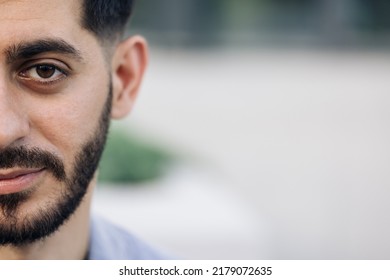 Half Face Portrait Of Young Man With Beard. Half Face Of Upset Bearded Caucasian Young Man Looking Straight To Camera While Standing Outdoors In Empty Town.