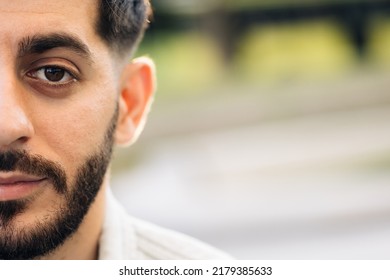 Half Face Portrait Of Young Man With Beard. Half Face Of Upset Bearded Caucasian Young Man Looking Straight To Camera While Standing Outdoors In Empty Town.