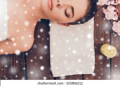 Half face portrait of young woman in sauna with snowflakes.