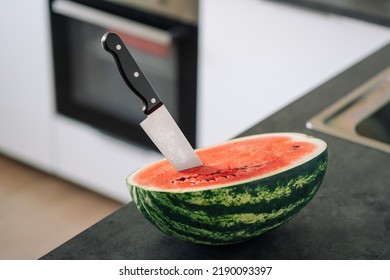 Half Of Fresh Sliced Watermelon With Knife On A Kitchen Table After The Refrigerator. Authentic Lifestyle. Home Cooking, Preparation Of Organic Food.