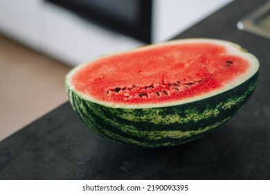 Half Of Fresh Sliced Watermelon On A Kitchen Table After The Refrigerator. Authentic Lifestyle. Home Cooking, Preparation Of Organic Food.