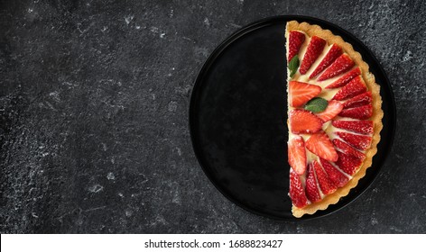 A Half Of Fresh Strawberry Flan On Black Background