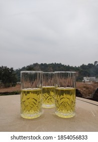 Half Full Glasses, N Hill In The Background With Smoggy Sky. 