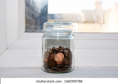 A Half Full Jar Of Money On A Window Sill