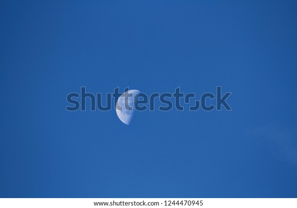 Half Full Moon on Brilliant Autumn Blue Sky in\
Early Morning with Clouds