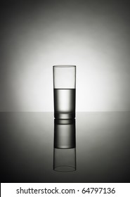 Half Glass Of Water On A Reflexion