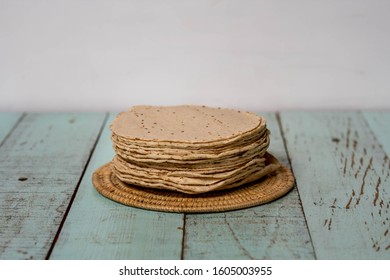 A half kilogram of freshly made tasty corn / maize Mexican tortillas, a staple of Mexican cuisine, on a rustic vintage wood table painted green. With room for text / space for copy. - Powered by Shutterstock