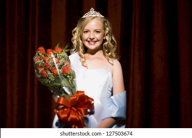 Half Length Of A Beauty Pageant Winner Smiling And Holding Roses