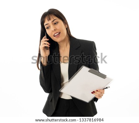 Half length portrait of young smiling beautiful businesswoman with folder speaking on mobile smart phone feeling confident and successful. In people, business, communication and technology concept.