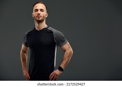 Half length portrait of young sporty guy in t-shirt and shorts standing on gray studio background. Serious millennial sportsman looking at camera. Healthy lifestyle and sports concept - Powered by Shutterstock