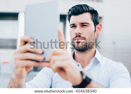 Half length of young handsome caucasian black hair modern businessman using a tablet taking photos - technology, social network concept