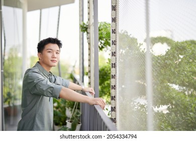 Half length of young handsome man standing on a balcony outdoor,