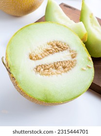 Half melon and sliced pieces of melon on white background. - Shutterstock ID 2315444701