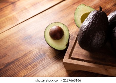 Half Mexican Avocado (persea Americana) On Rustic Wooden Table. Main Ingredient To Prepare Guacamole. Close Up Image