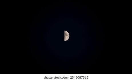 Half moon against a dark night sky, showing lunar surface details in a minimalistic, isolated view. - Powered by Shutterstock