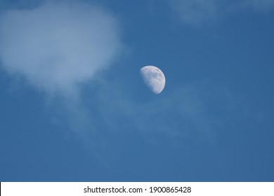 Half moon among the clouds in the evening sky - Powered by Shutterstock