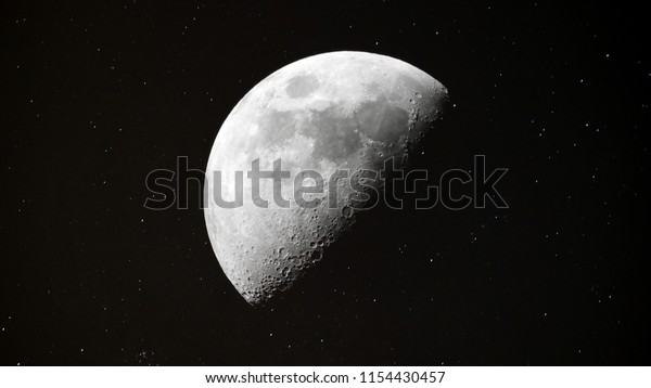 Half Moon background / The Moon is an astronomical\
body that orbits planet Earth and is Earth\'s only permanent natural\
satellite. It is the fifth-largest natural satellite in the Solar\
System