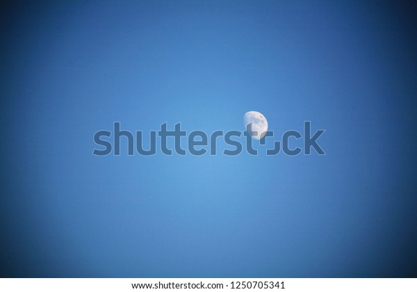 The half moon in the blue\
sky